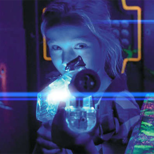 Kinderen spelen lasergame in donkere arena met blacklight bij Monkey Town